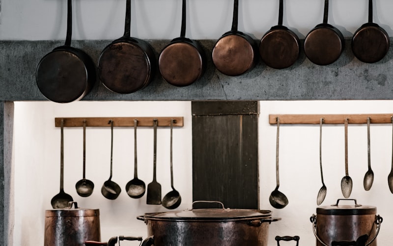 Organisierte Küche mit Batch-Cooking-Zutaten, Behältern und einem Wochenplan an der Wand