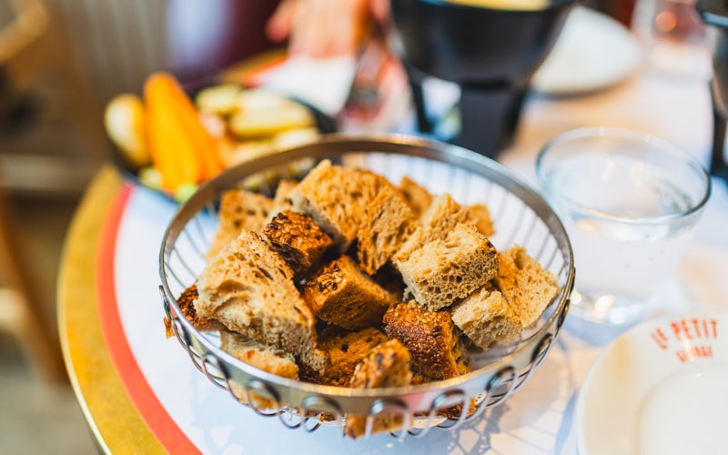 Verschiedene Raclette-Pfännchen mit unterschiedlichen Füllungen: klassisch, vegetarisch und mit Meeresfrüchten